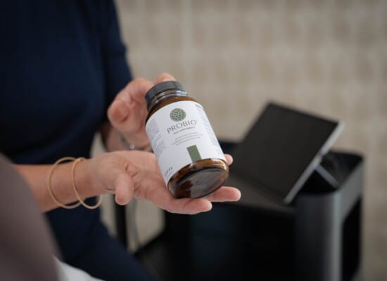 Hände, die eine Packung Nahrungsergänzungsmittel "Probio" in die Kamera halten